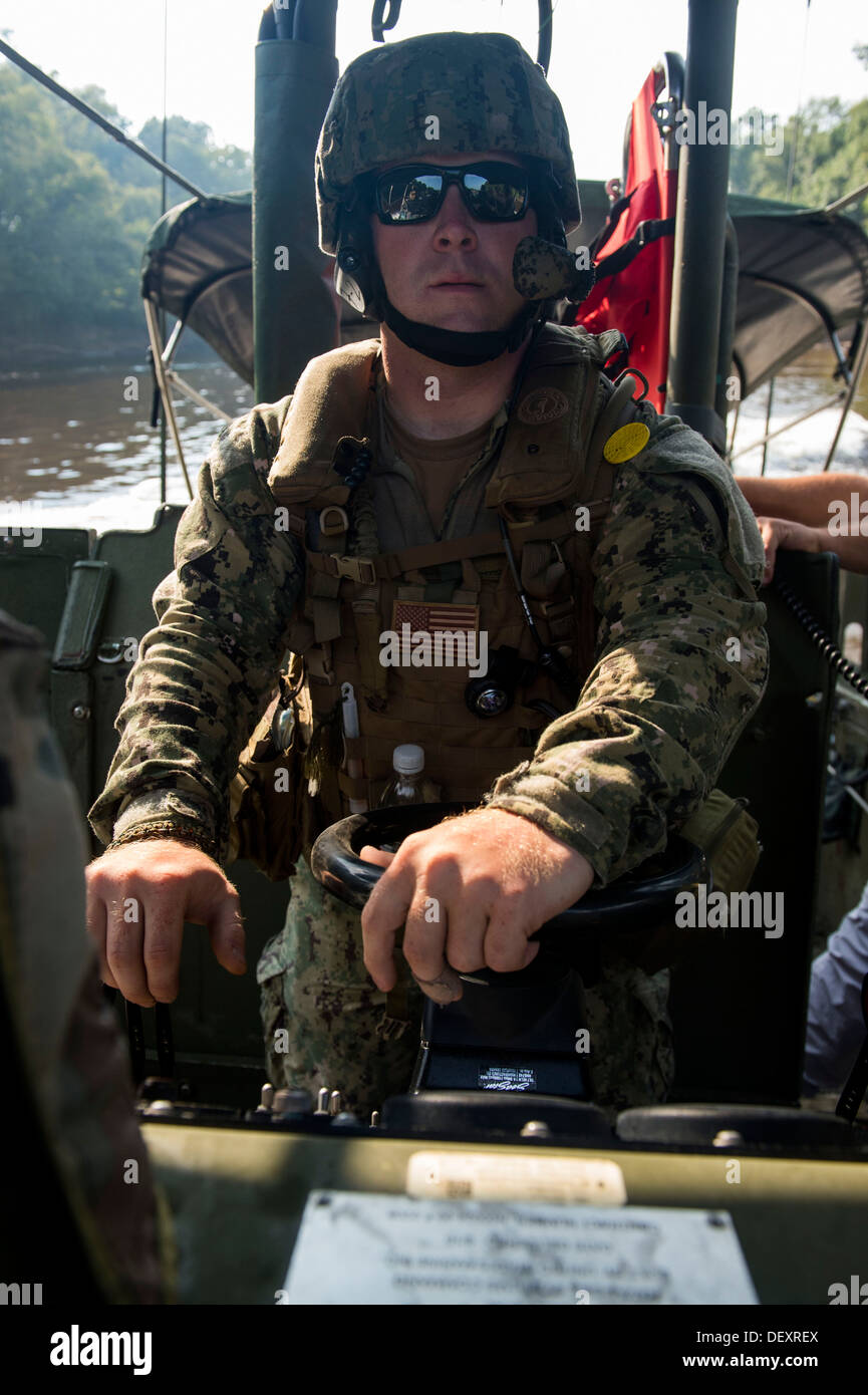 Aviation Ordnanceman 2a classe Matthew Watson esegue un inserto di simulazione di sicurezza fluviale, i membri del team (RSIM) con un assalto fluviale barca sul Cape Fear River durante il Crewman fluviale corso (RCC). Gli studenti con rsim e RCC si sta completando il tappo Foto Stock