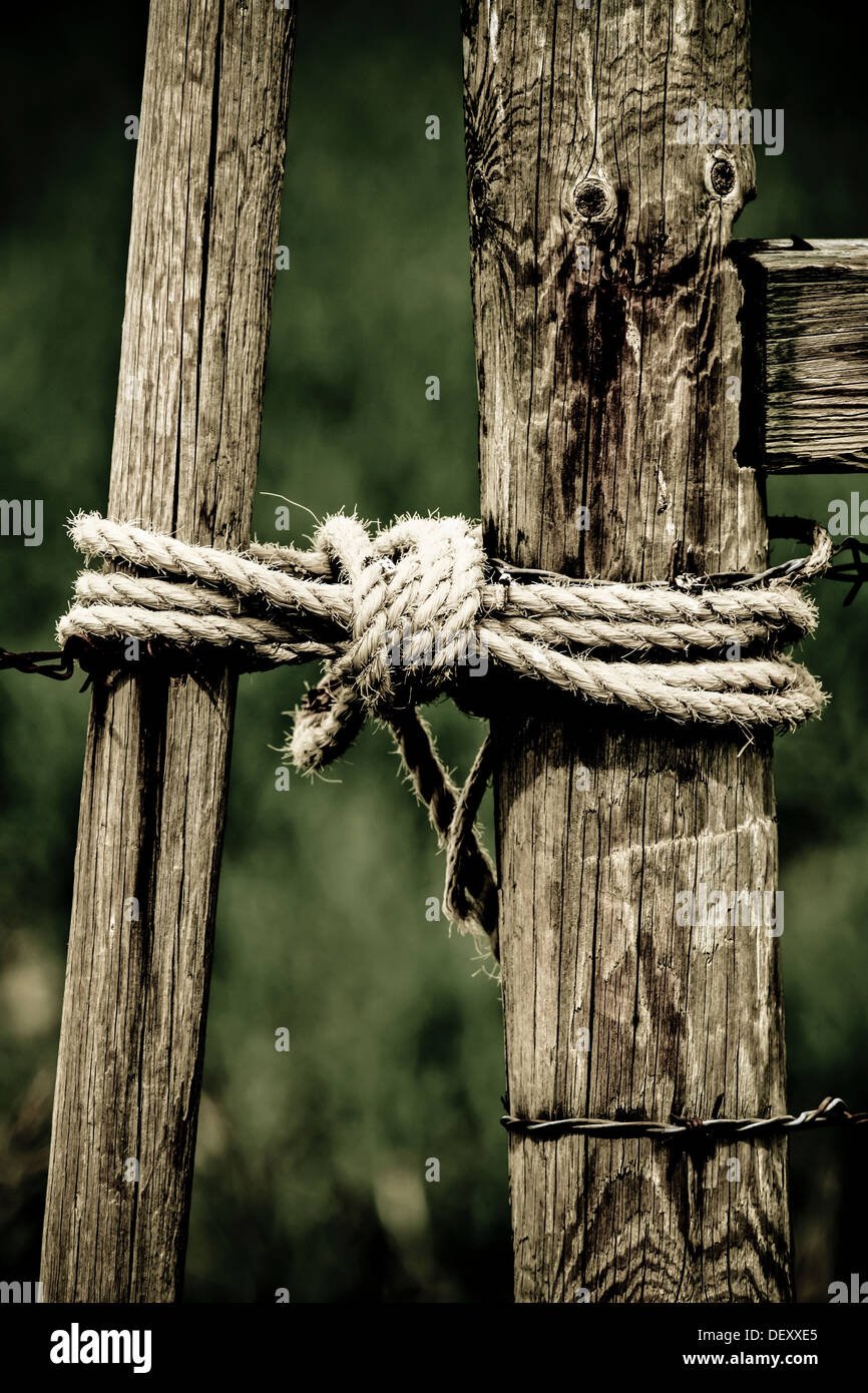 Drammatico, scenic immagine rurale della staccionata in legno & gate, con fune tenendolo chiuso. Suggerendo cowboy, ranch di bestiame, rurale, vecchio Foto Stock