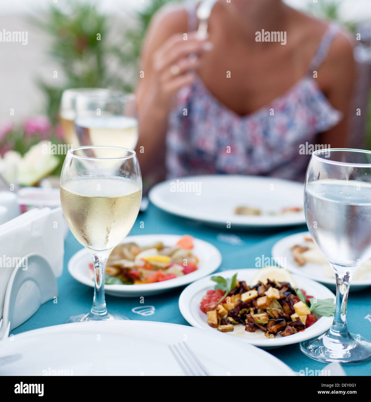 Cena romantica con vino bianco. Sullo sfondo di una ragazza è al di fuori della messa a fuoco. Foto Stock
