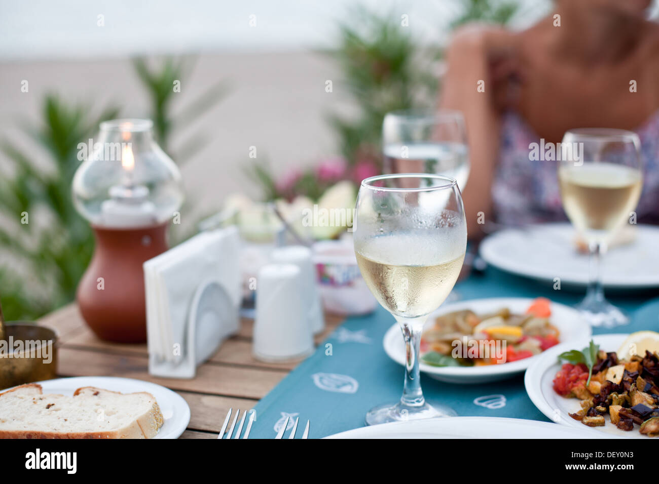 Cena romantica con vino bianco. Sullo sfondo di una ragazza è al di fuori della messa a fuoco. Foto Stock