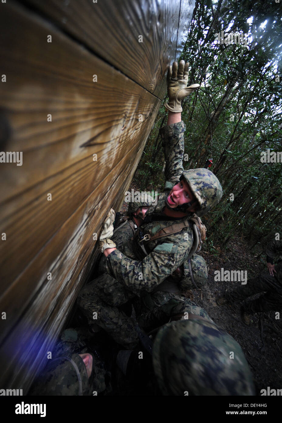 Naval Mobile Battaglione di costruzione (NMCB) 3 costruzione meccanico di terza classe Nicholas Edwards balzi in avanti fuori i suoi membri della squadra di ri Foto Stock