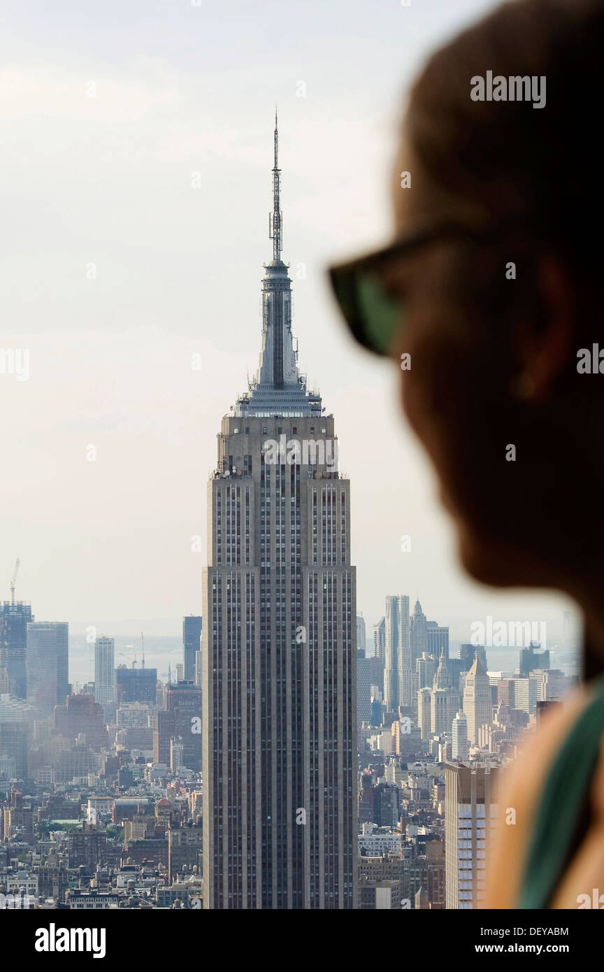 La donna a una finestra del Rockefeller Center con vista dell'Empire State Building, Manhattan, New York, Stati Uniti d'America Foto Stock