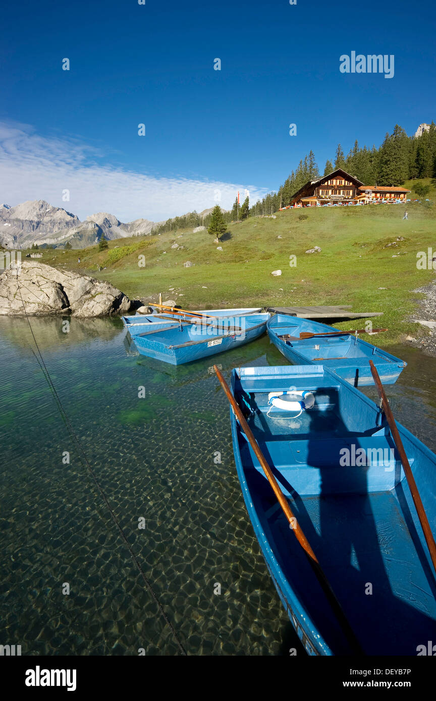 Barche e una locanda Oeschinensee lago, Kandersteg, Oberland bernese, il Cantone di Berna, Svizzera, Europa Foto Stock
