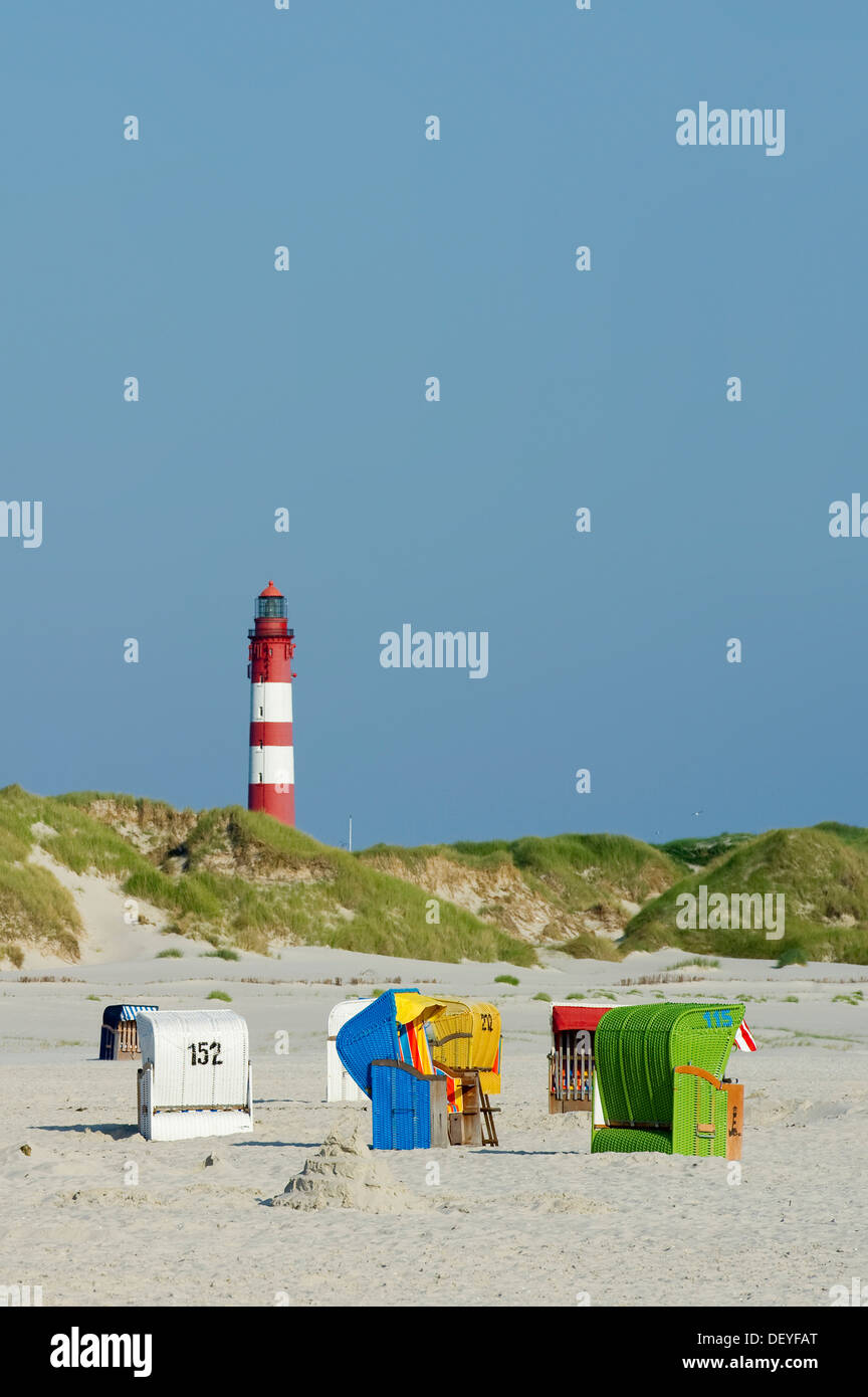 Spiaggia con colorate sedie a sdraio e un faro, Nebel, Amrum, Amrum, Nord Isole Frisone, Schleswig-Holstein, Germania Foto Stock