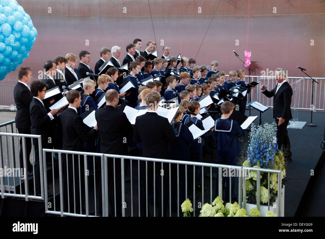 Copenaghen, Settembre 25th, 2013. Oggi HRH Principessa Mary di Danimarca denominato ufficialmente il triple-E CONTENITORE maestosa nave Maersk a Langelinie nel porto di Copenhagen. La cerimonia ha segnato anche l'apertura dell'area espositiva e visite a bordo della nave per il pubblico. Il Copenhagen Royal coro a cappella è il canto antico danese e canzoni patriottiche durante il nome dando cerimonia. La rottura della bottiglia di champagne da il nome dando in background. Credito: Niels Quist/Alamy Live News Foto Stock