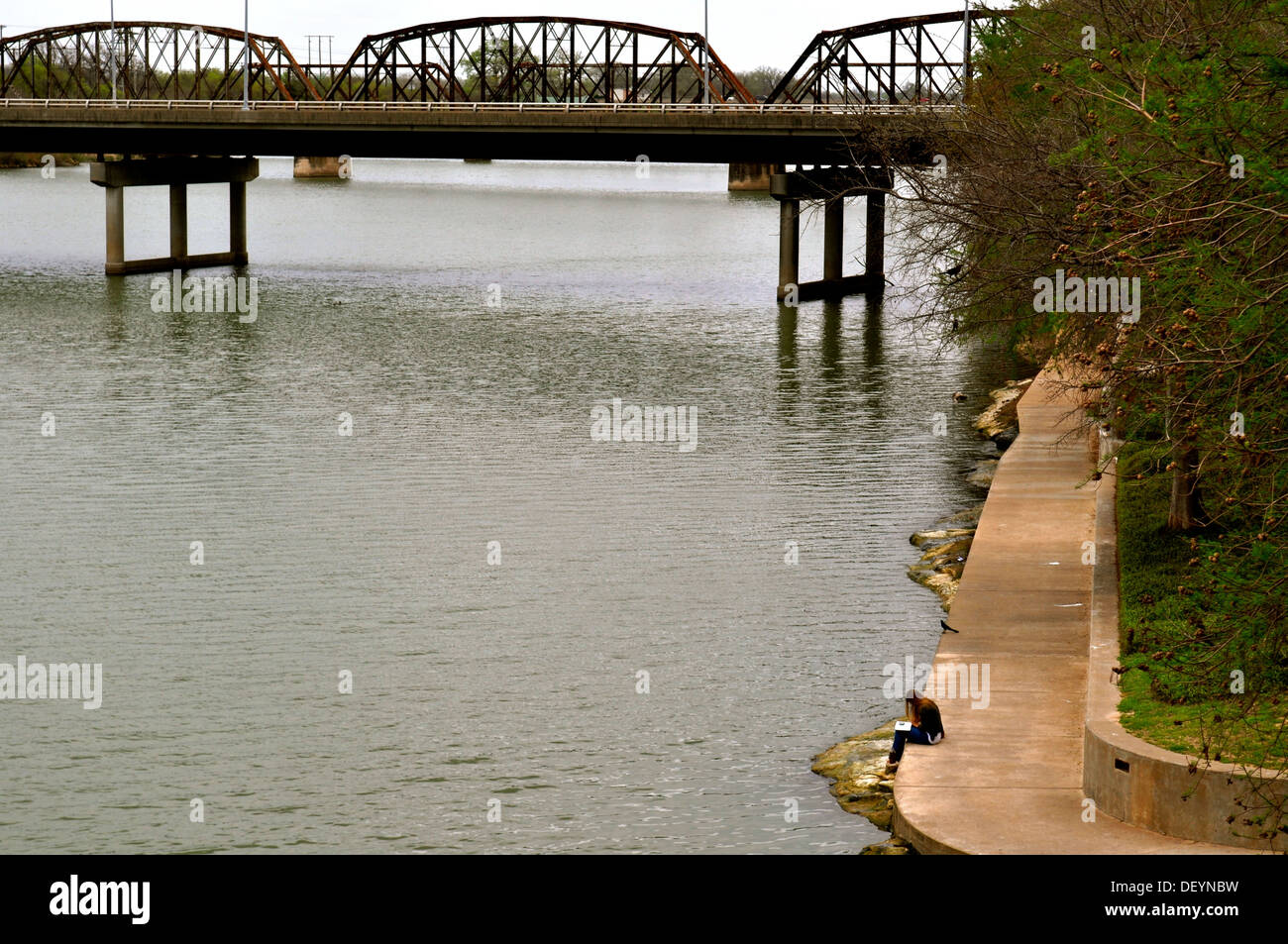 Waco donna legge sulla banca del fiume Foto Stock