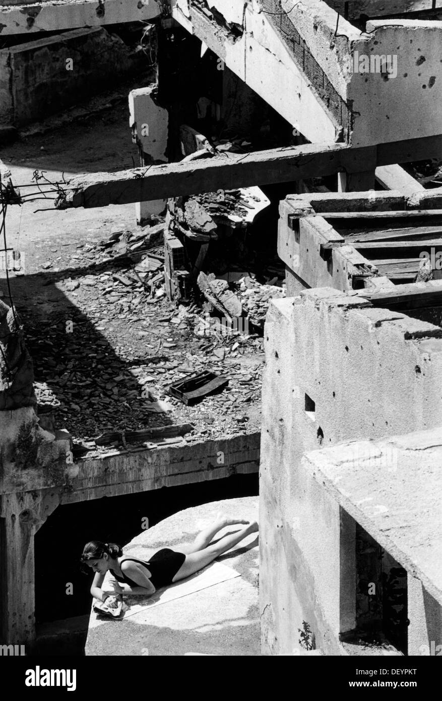 Ragazza a prendere il sole sulle rovine di oriente musulmano Mostar distrutto in guerra con i Croati. La Bosnia 1996 Foto Stock