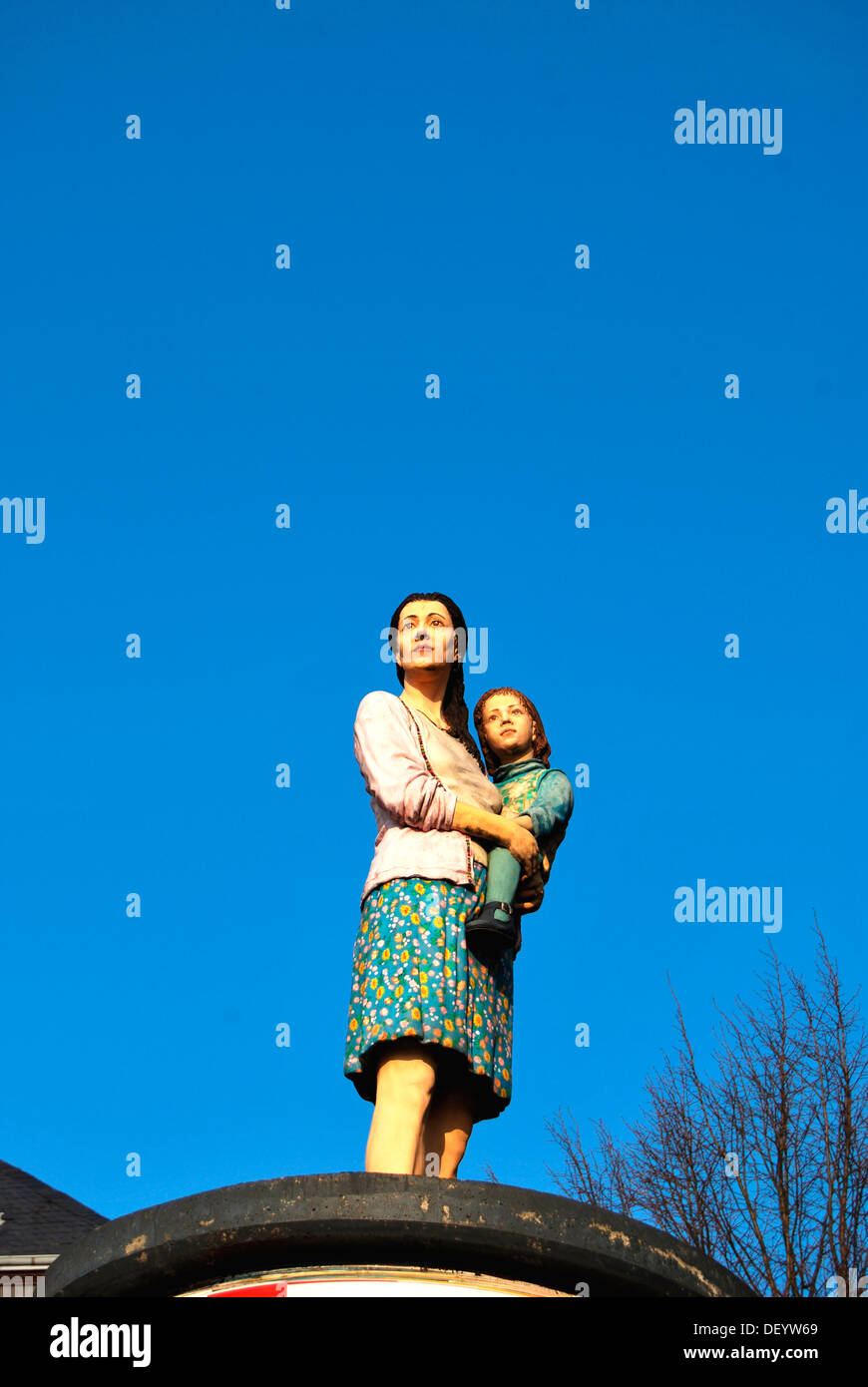 Lo straniero, la donna con il bambino in braccio, scultura su una colonna di pubblicità, Duesseldorf, nella Renania settentrionale-Vestfalia Foto Stock