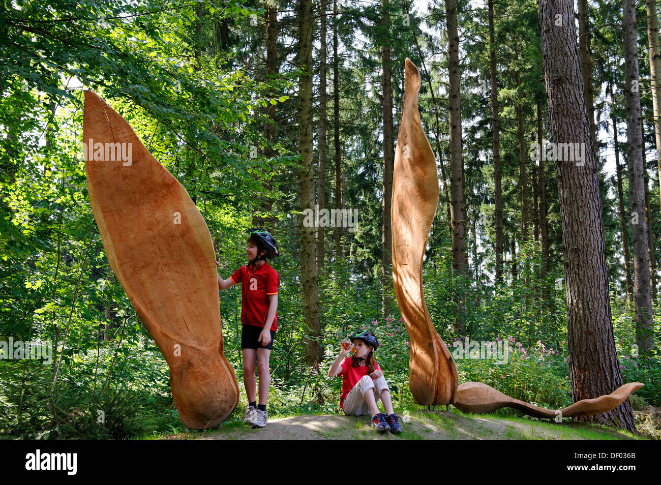 I bambini presso la scultura Ahornsamen nella foresta Weltwald, Landesarboretum giardino, Kranzberg, Kranzberger Forst, Alta Baviera Foto Stock