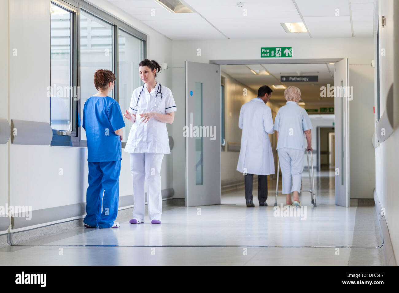 Corridoio di ospedale con medici, infermieri e senior paziente femmina Foto Stock