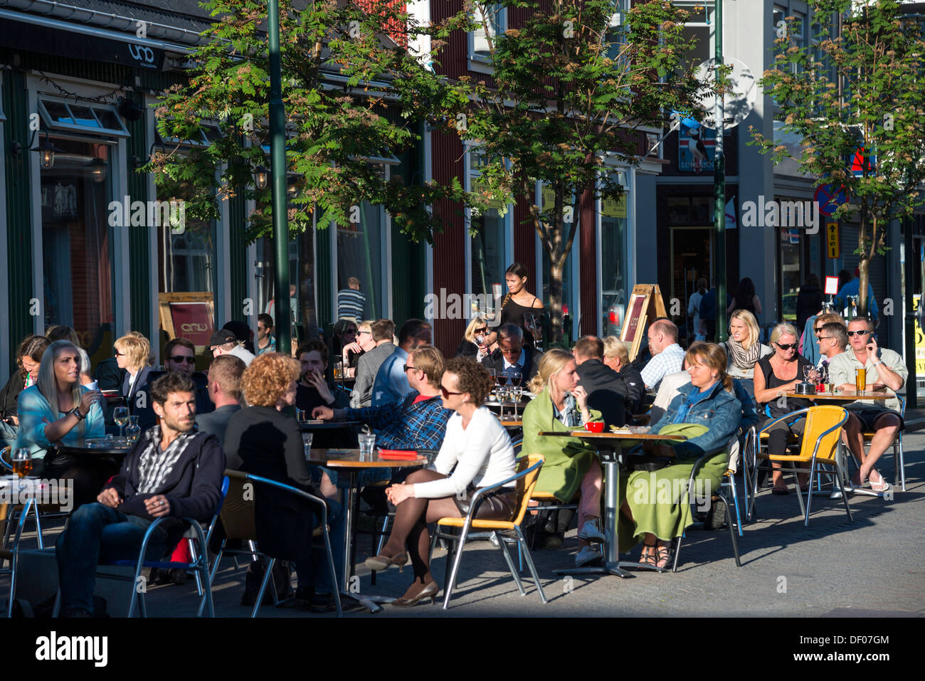 La gente seduta in una street cafe scene di strada, Reykjavík, Islanda, Europa Foto Stock