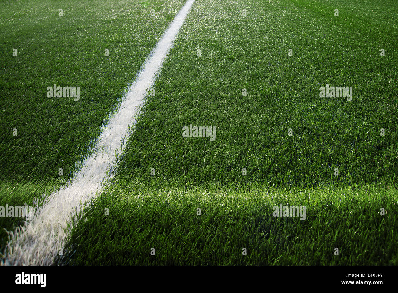 Tappeto erboso artificiale al campo di calcio, verde erba in plastica come sfondo. Foto Stock