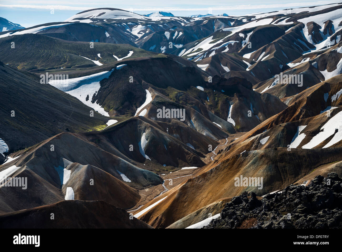 Vista dal vulcano Brennisteinsalda al innevate montagne di riolite, Landmannalaugar, Fjallabak Riserva Naturale Foto Stock