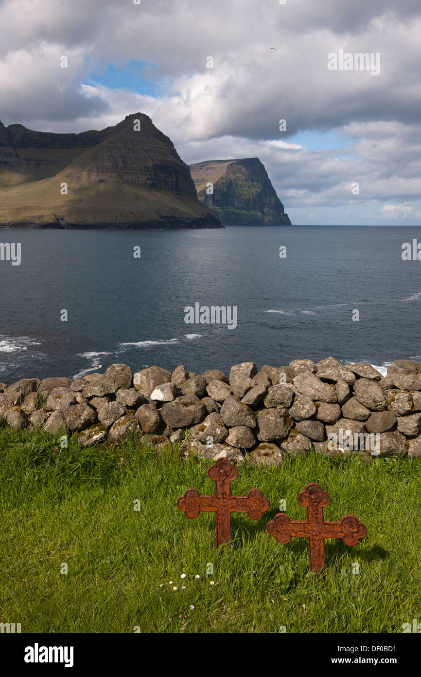 Vecchio arrugginito attraversa gravi in un piccolo cimitero dal mare, Vidareidi, Viðareiði, Isole Faerøer, Danimarca, Nord Europa, Europa Foto Stock