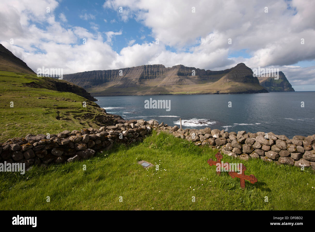 Vecchio arrugginito attraversa gravi in un piccolo cimitero dal mare, Vidareidi, Viðareiði, Isole Faerøer, Danimarca, Nord Europa, Europa Foto Stock