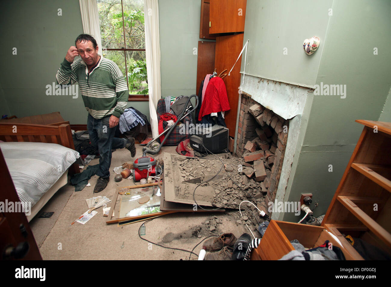 Un uomo nella sua casa danneggiata il giorno dopo un grave terremoto ha colpito Seddon, Marlborough, Nuova Zelanda Foto Stock