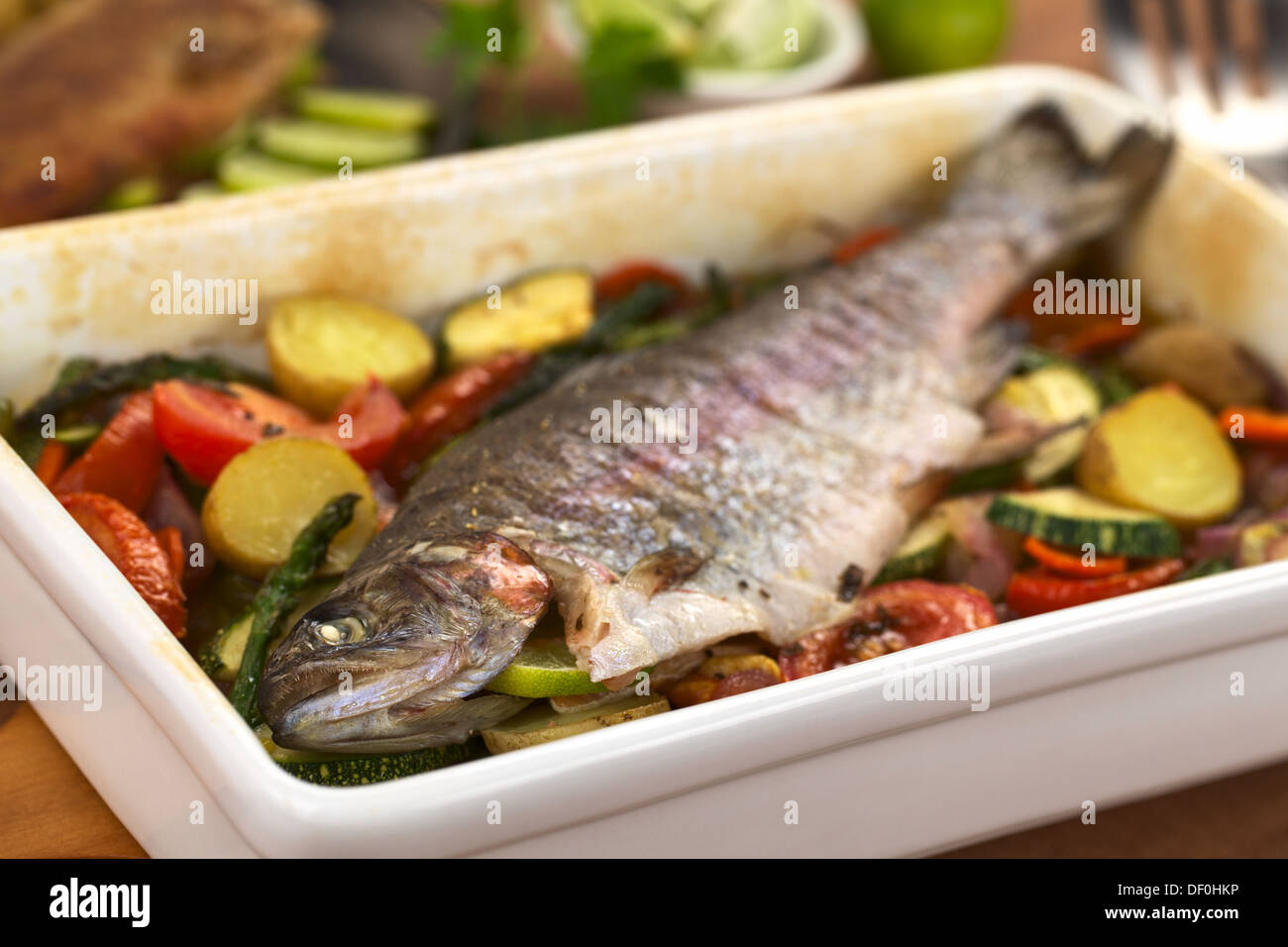 Trota al forno e verdura (messa a fuoco selettiva, concentrarsi sull'occhio di pesce) Foto Stock