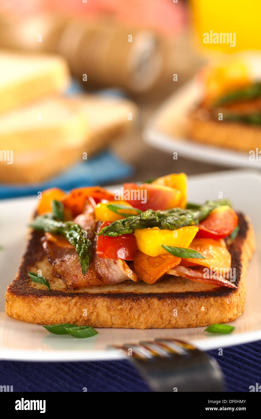 Asparagi al forno, mango, pomodoro, la carota e la pancetta a sandwich integrale sul pane tostato Foto Stock