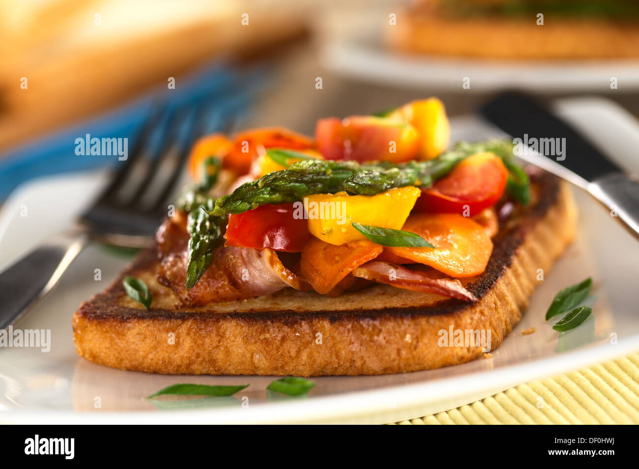 Asparagi al forno, mango, pomodoro, la carota e la pancetta a sandwich integrale sul pane tostato Foto Stock