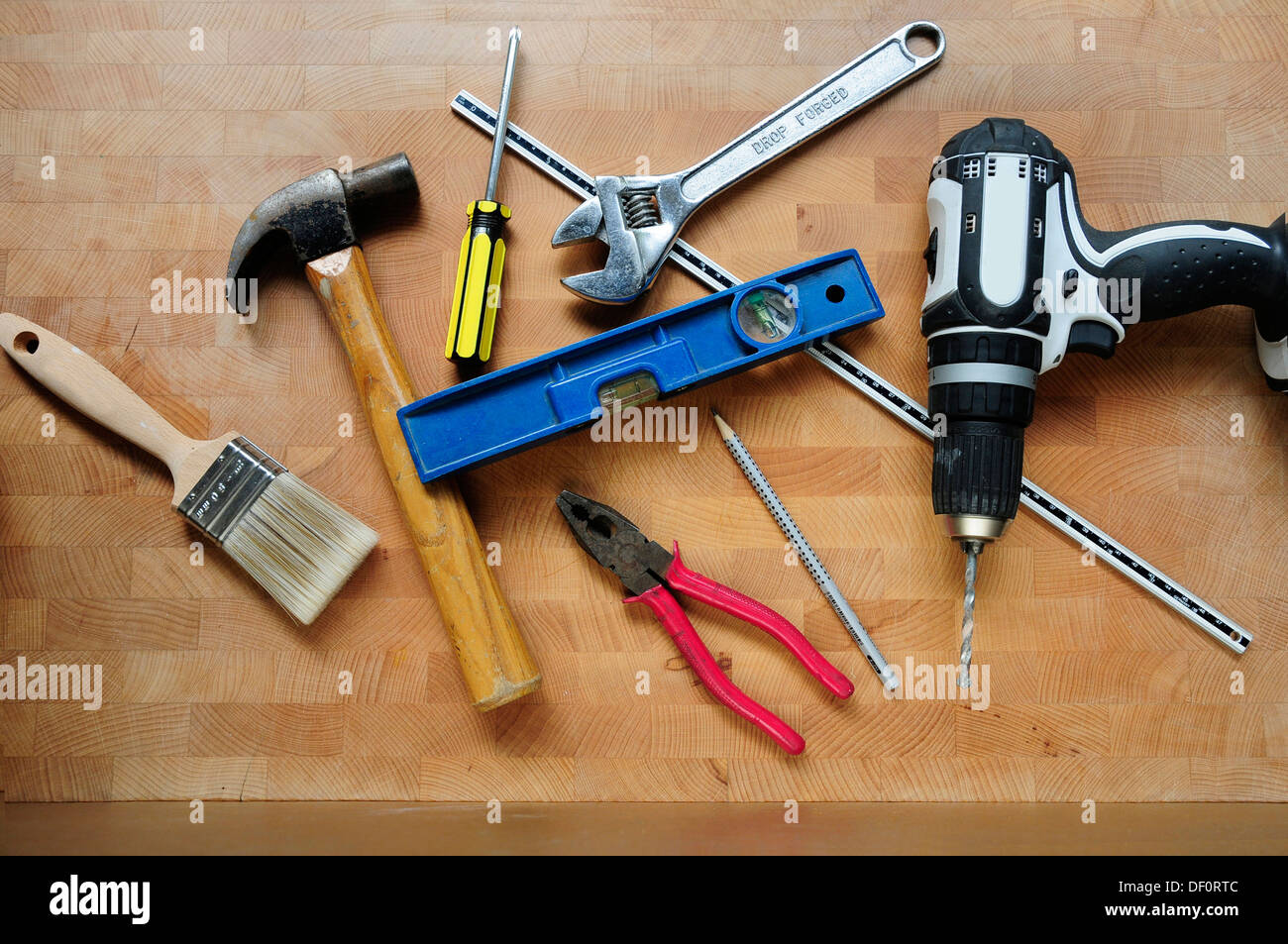 Workman e tuttofare DIY utensili disposti su un tavolo di legno. Foto Stock