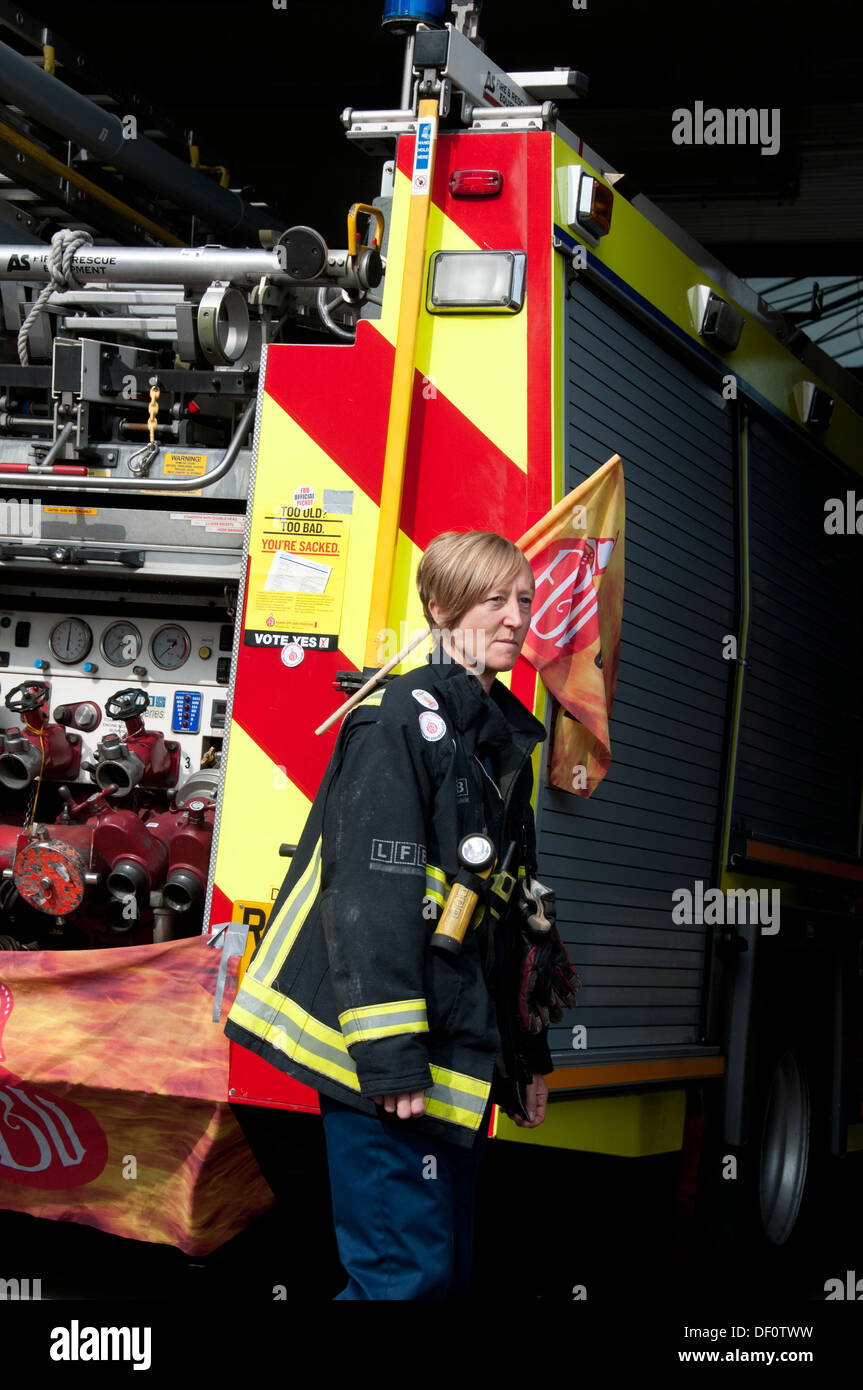 Vigili del fuoco sciopero da 12-4pm in una protesta contro le minacce alla loro pensioni. Una femmina di vigile del fuoco si trova di fronte il suo motore. Foto Stock