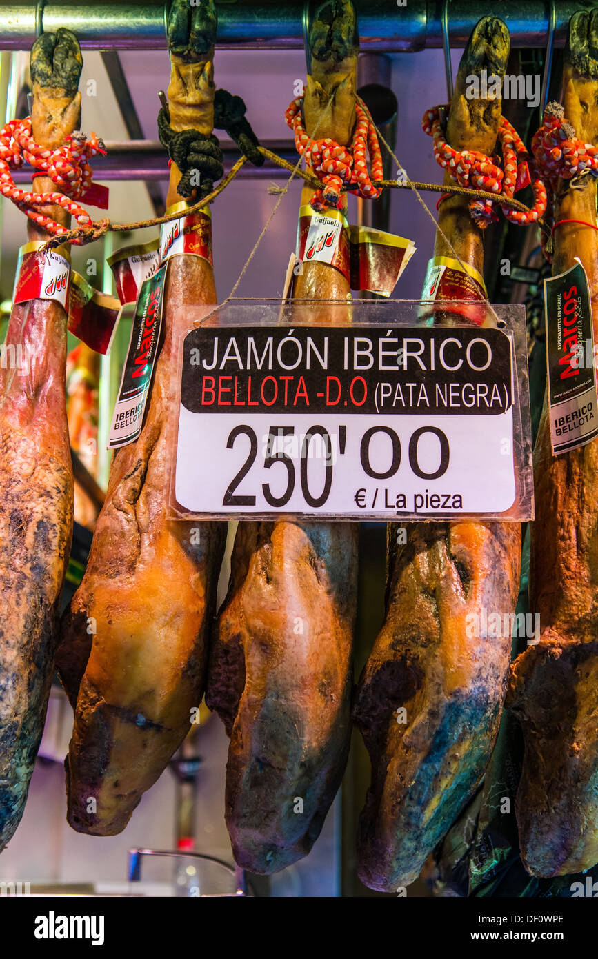 Pata Negra jamon iberico o i prosciutti spagnoli appendere nel mercato La Boqueria, Barcellona, in Catalogna, Spagna Foto Stock