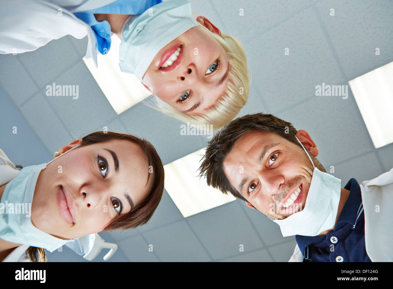 Dentista e team guardando verso il basso durante il trattamento sul paziente Foto Stock