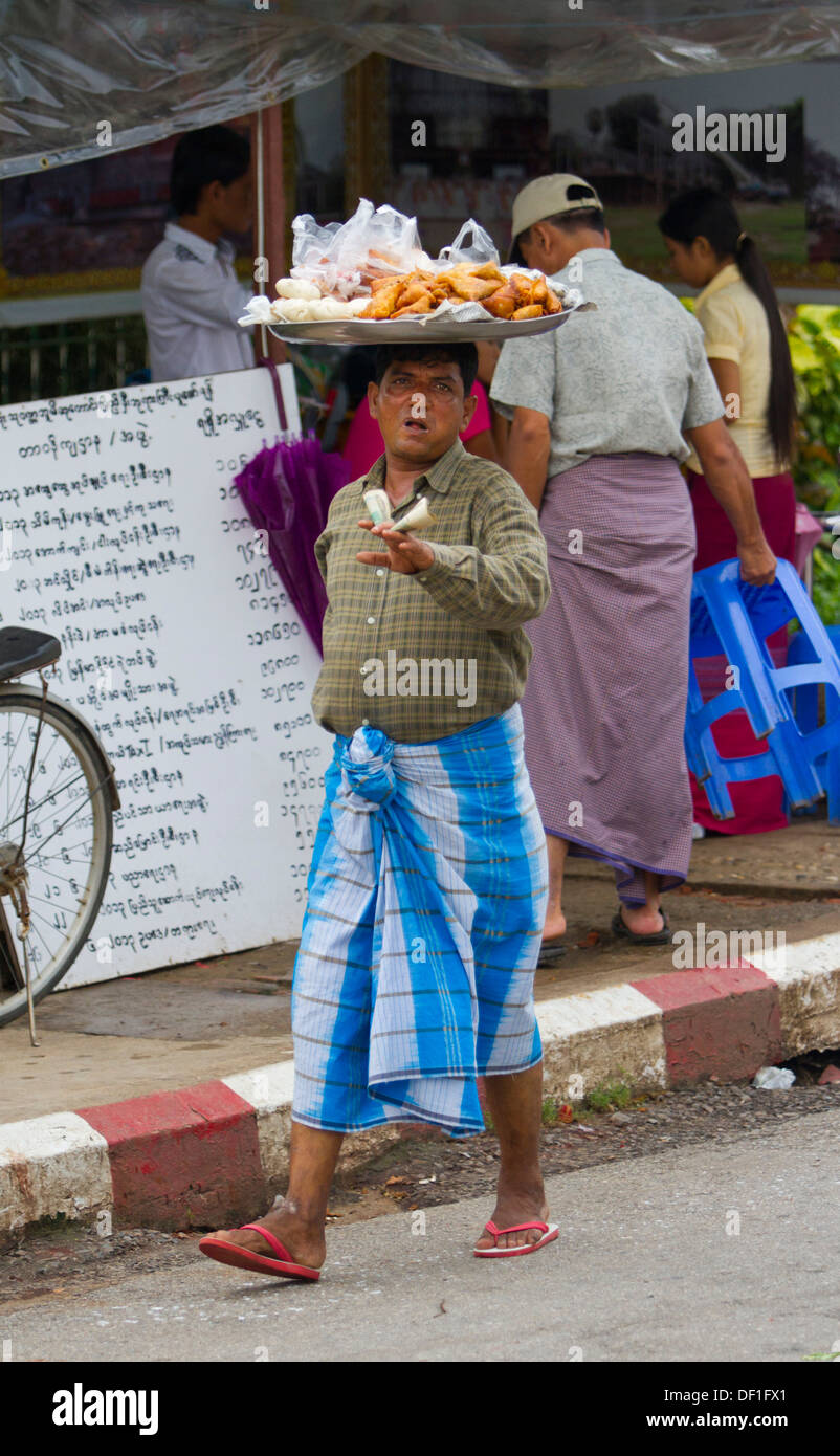 Un uomo birmano vende cibo ad una fermata di autobus di Mawlamyine e Birmania. Foto Stock