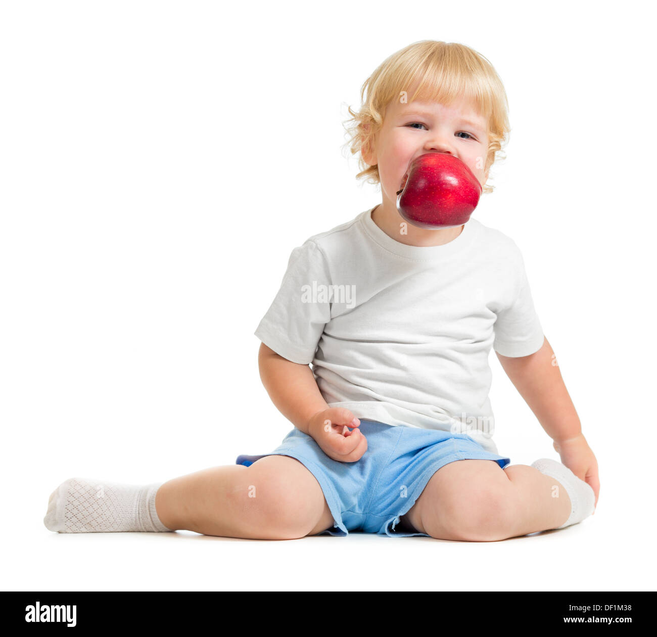 Kid mantenendo apple in bocca Foto Stock