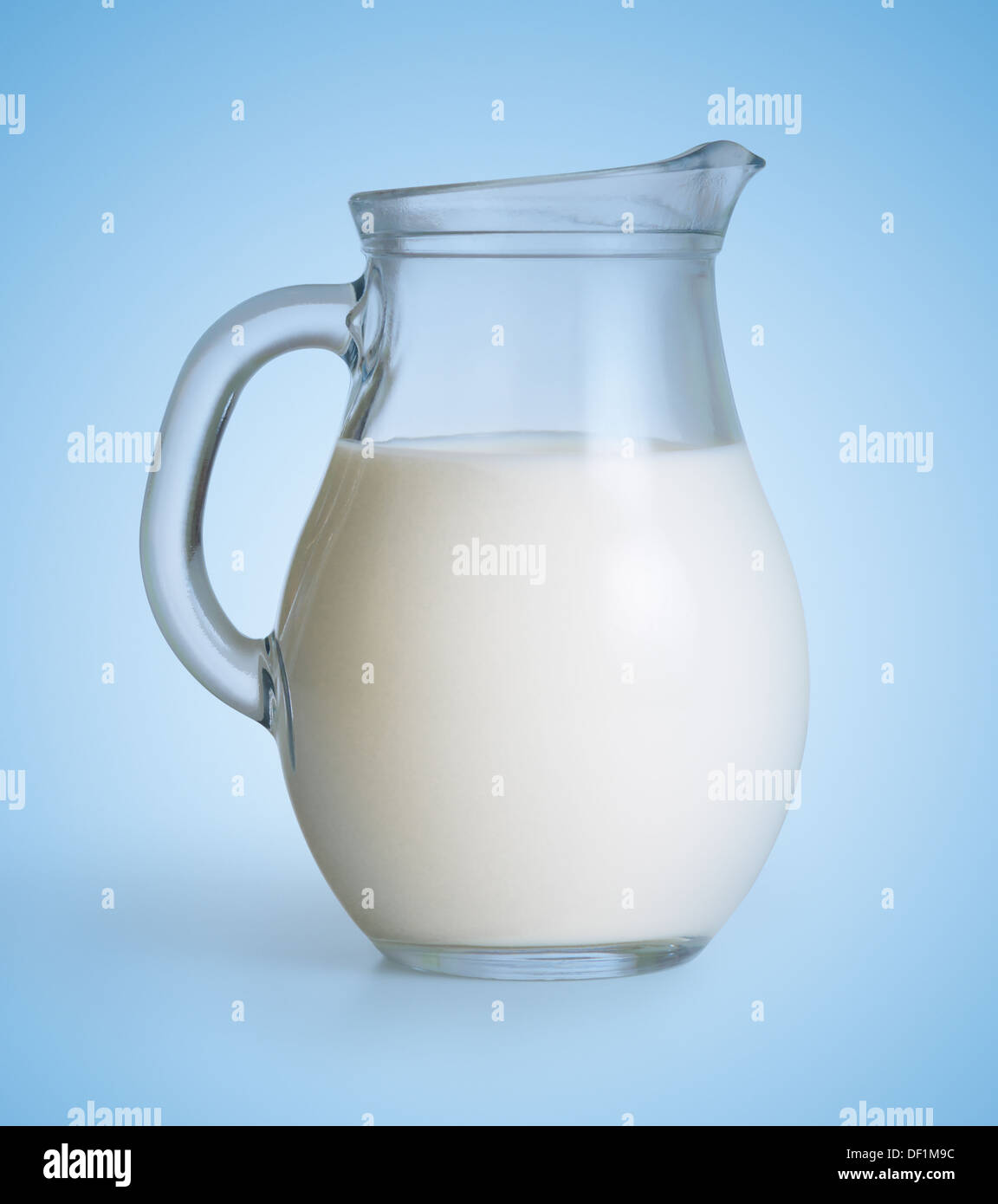 Latte caraffa di vetro su sfondo blu Foto Stock