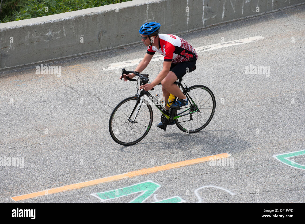 Ciclista in sella determinata barriera stradale la pedalata Foto Stock