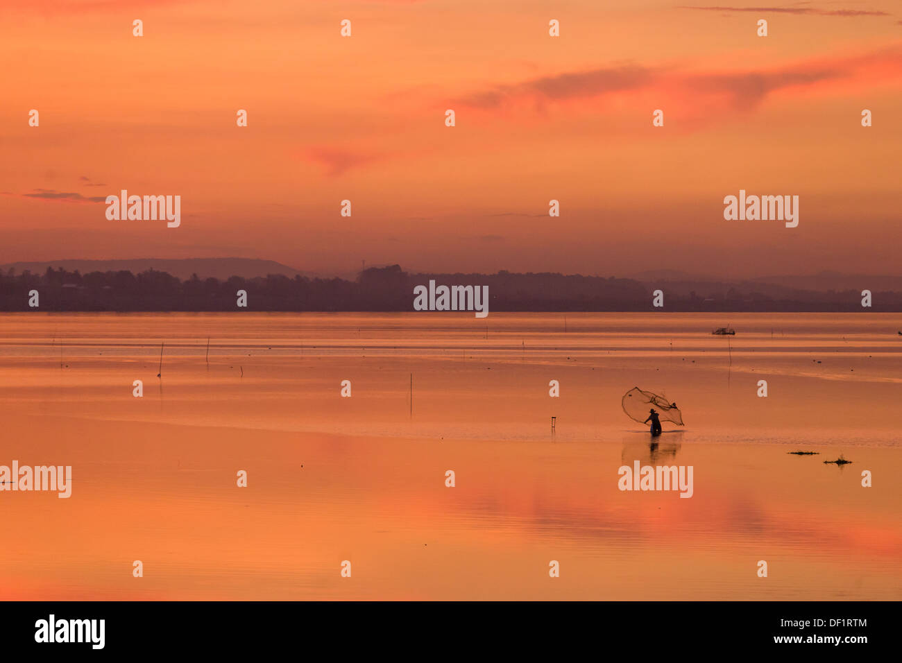 Fisherman colata di una rete da pesca nel fiume Mekong al tramonto, Vientiane, Laos Foto Stock