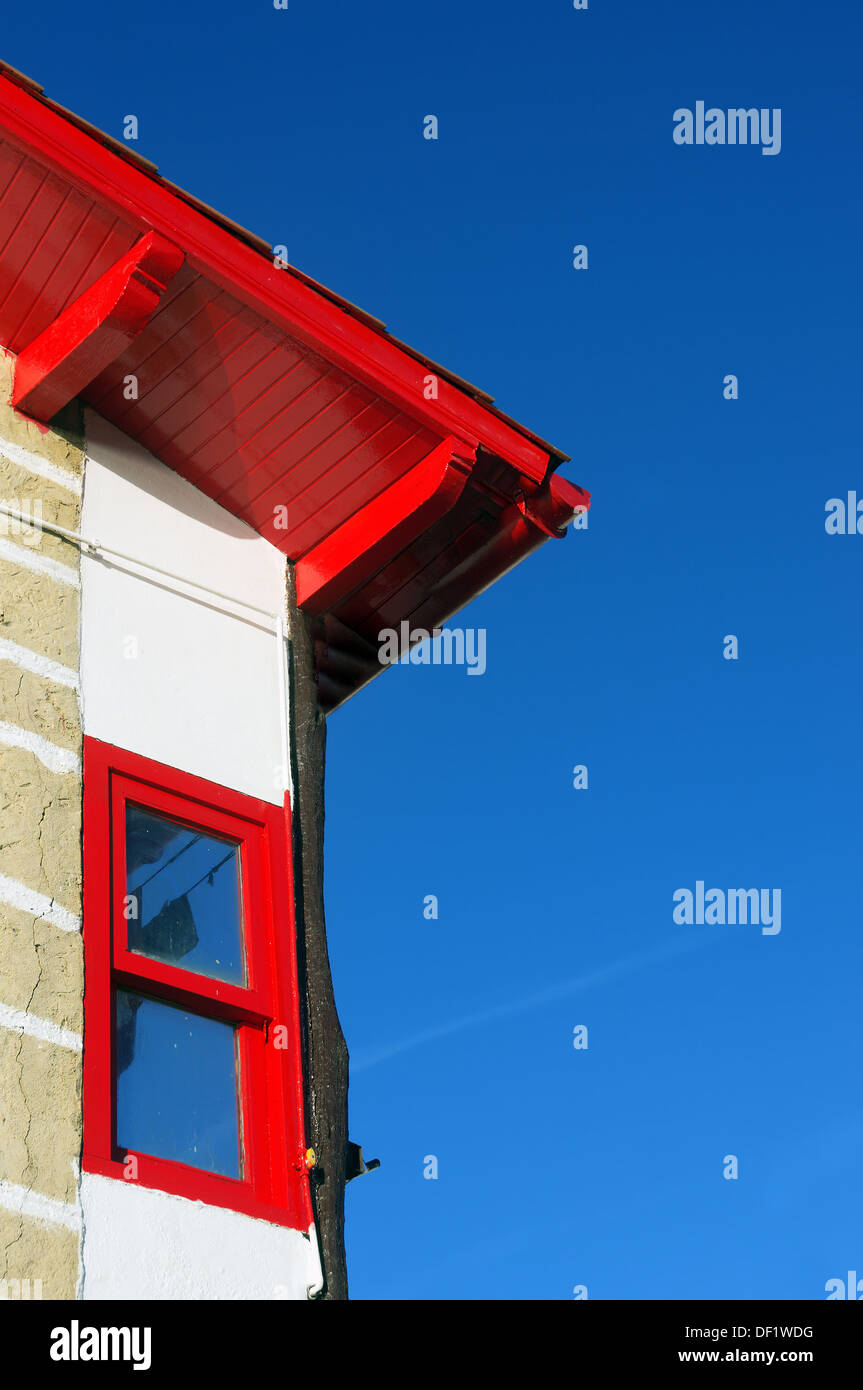 La facciata della casa con il tetto rosso e la finestra contro il cielo blu in Puerto Viejo, Getxo. Foto Stock