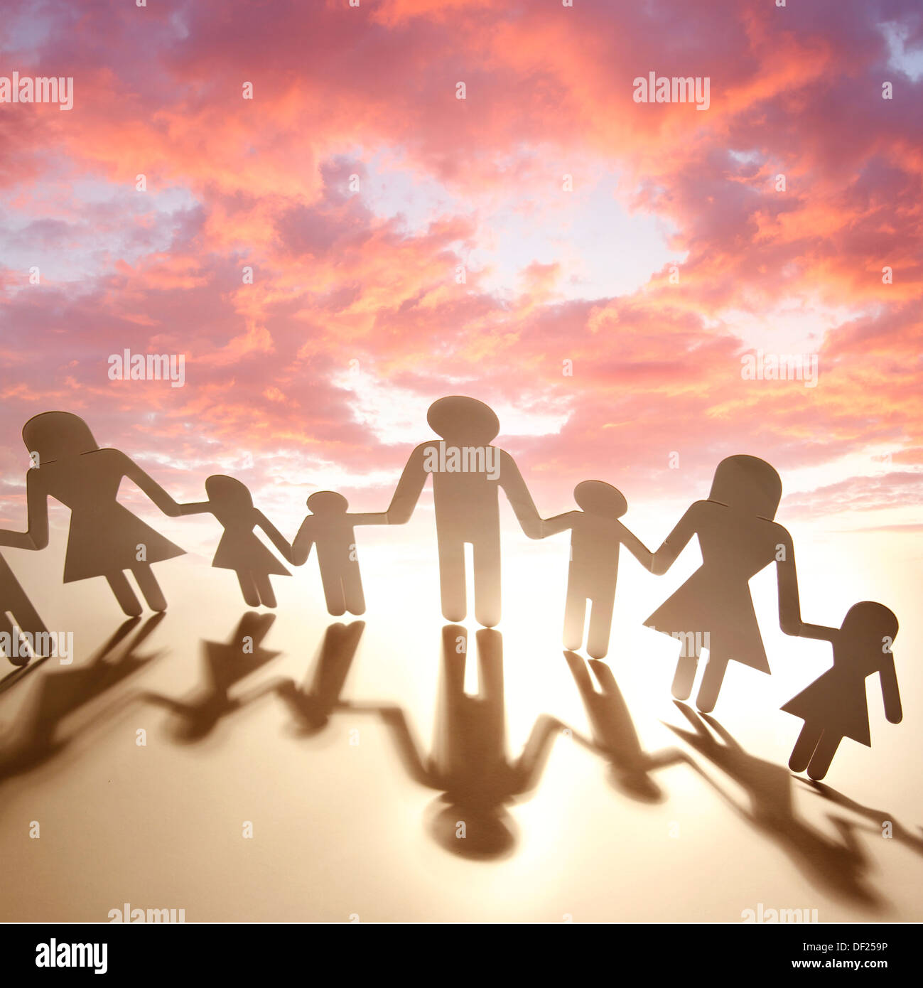 Famiglia tenendo le mani davanti al tramonto Foto Stock