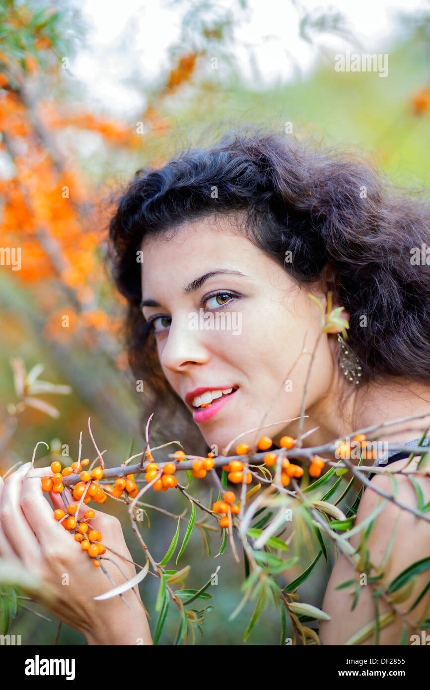 Bella giovane donna tenere il ramo con uva spina Foto Stock