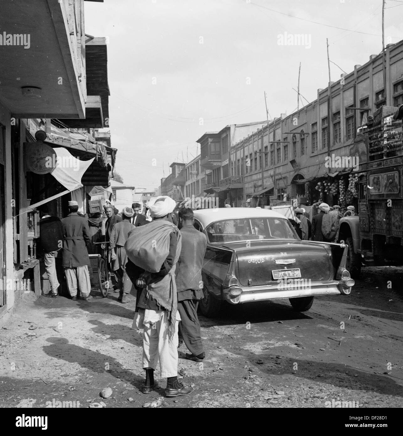 Immagine storica degli anni 1950 di J Allan Cash che mostra una scena di strada trafficata a Kabul, Afghanistan. Gli anni '50 e '60 sono stati un periodo relativamente pacifico, poiché si sono compiuti sforzi per un certo grado di modernizzazione e rendere il paese una società più aperta e prospera. Questo è giunto alla fine negli anni '70 con invasioni, colpi di stato e guerre civili. Foto Stock