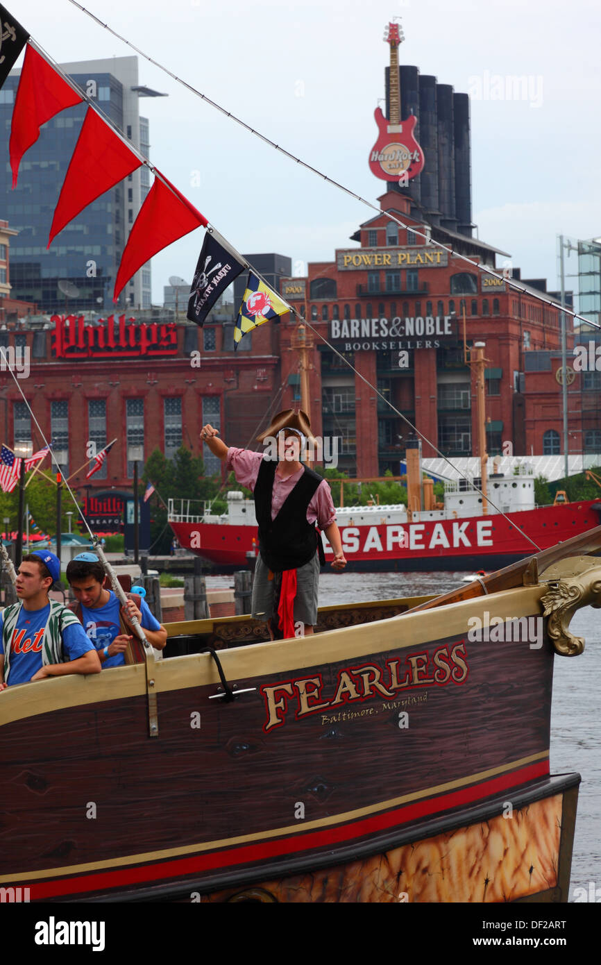 Turisti che si godono un urbano pirati gita in barca intorno al porto interno, alimentazione impianto edificio dietro, Baltimore, Maryland. Stati Uniti d'America Foto Stock