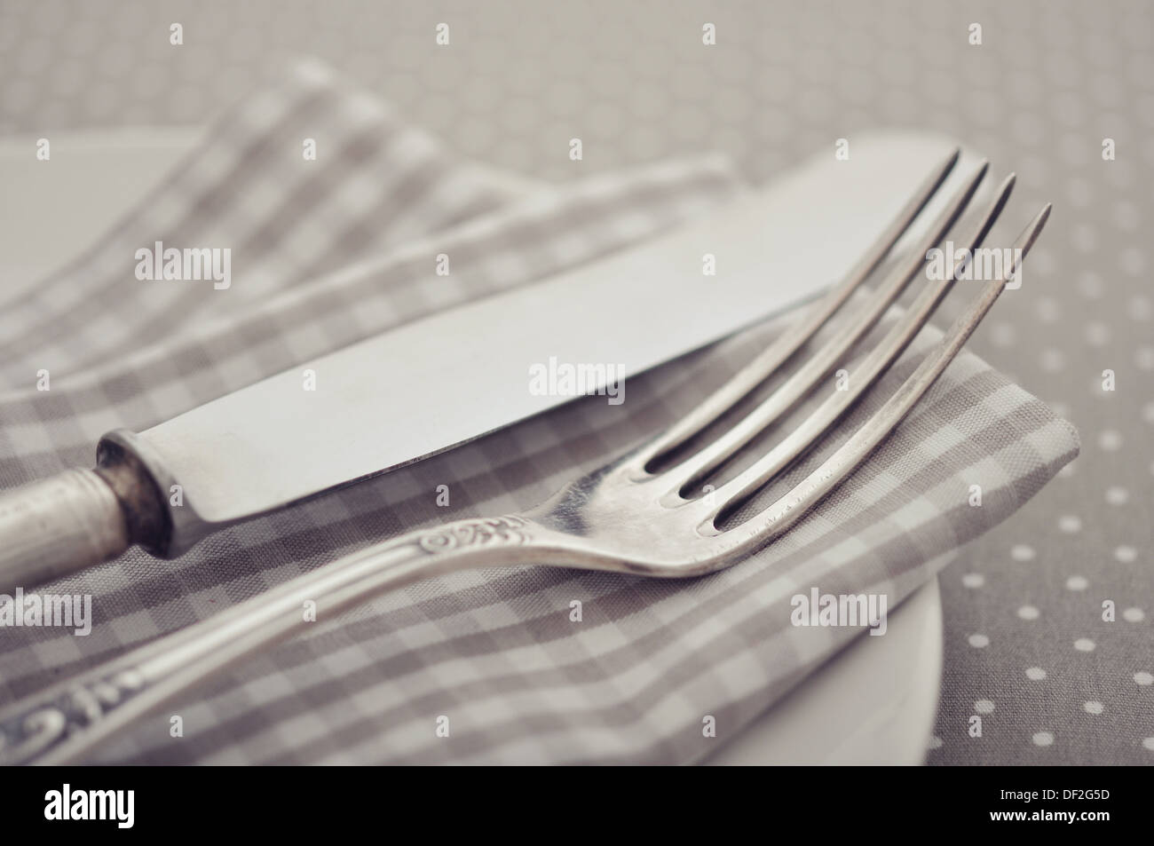 Piastra bianca, coltello e forchetta sulla luce polka dot sfondo. Foto Stock