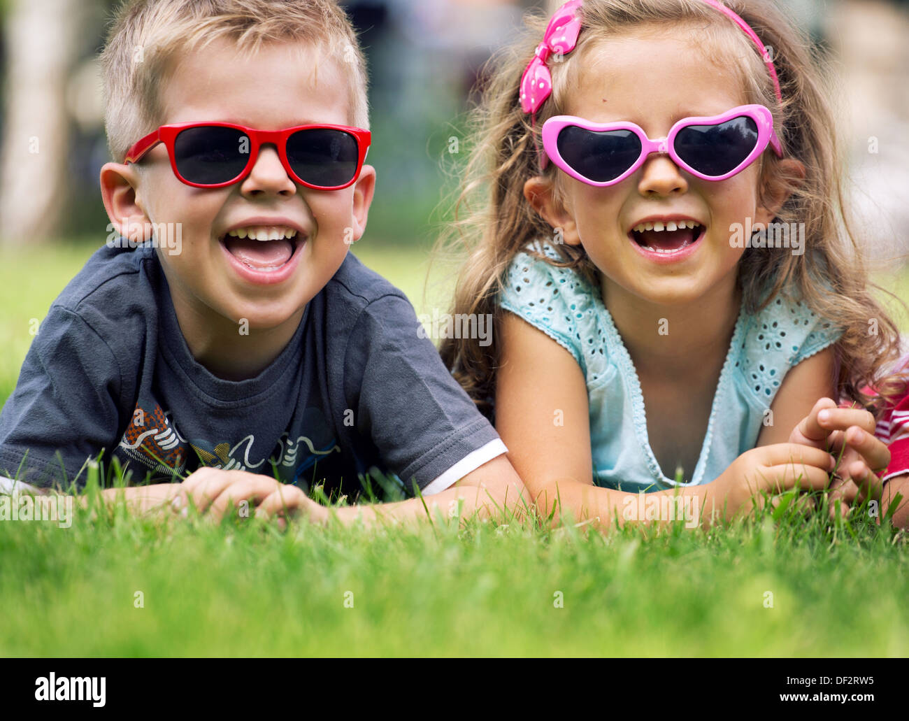 Carino piccoli bambini con occhiali da sole di fantasia Foto Stock