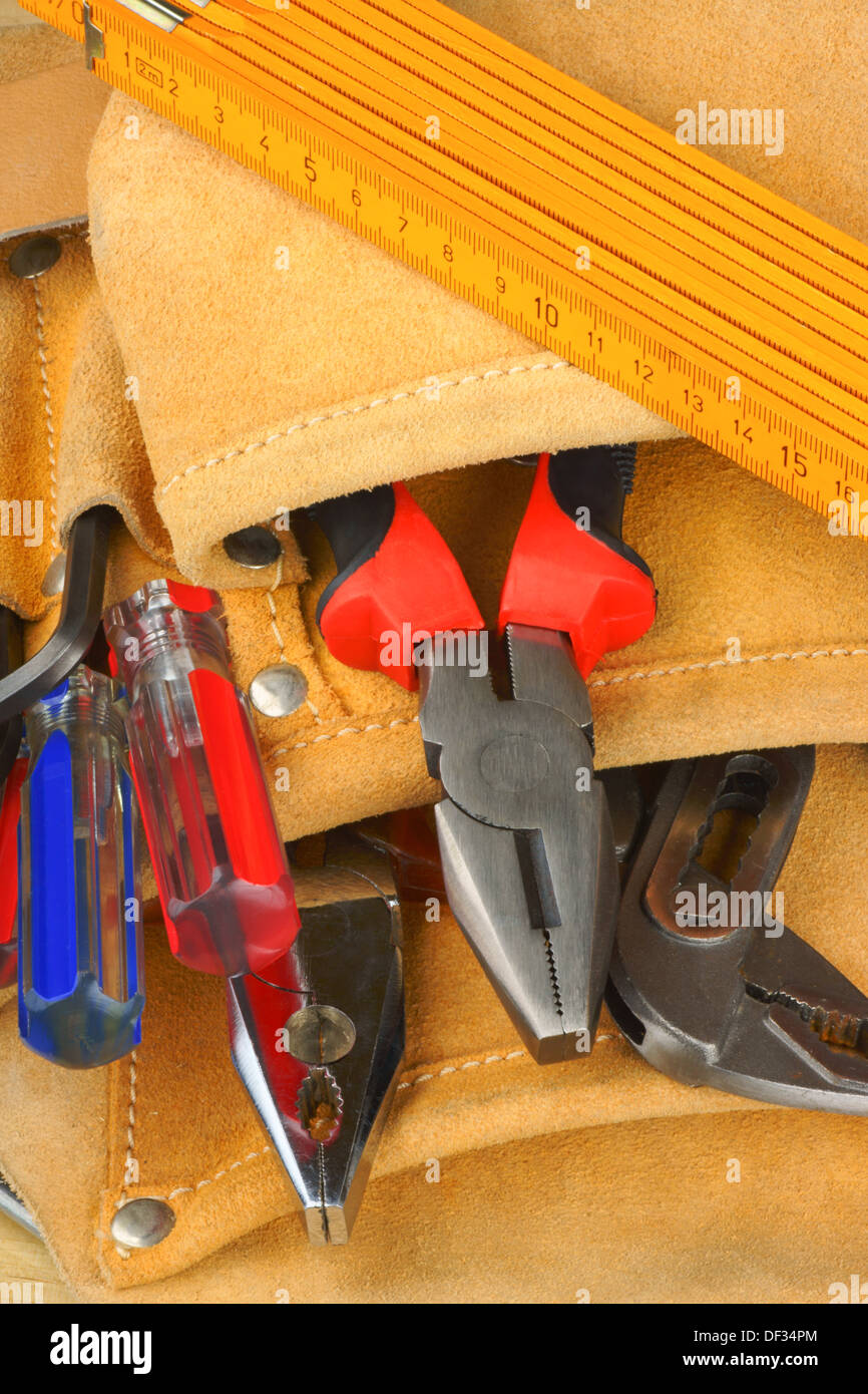 Lavoratore manuale tool set con alcuni cacciaviti, righello metrico, chiave a tubo e alcune coppie di pinze in una borsa portautensili Foto Stock