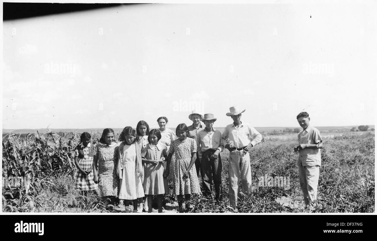 I membri del club 4-H sono mostrati in un giardino, impegnati in attività agricole e di giardinaggio. Il programma 4-H si concentra sullo sviluppo dei giovani e sull'apprendimento pratico in agricoltura e economia domestica. Foto Stock