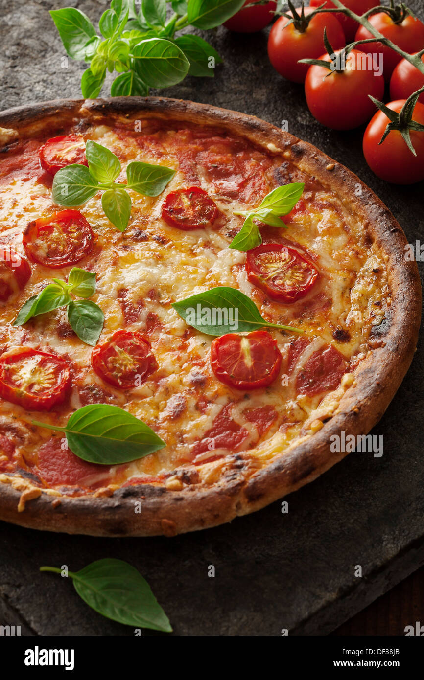Rustico pizza italiana con mozzarella di bufala, i formaggi e le foglie di basilico Foto Stock