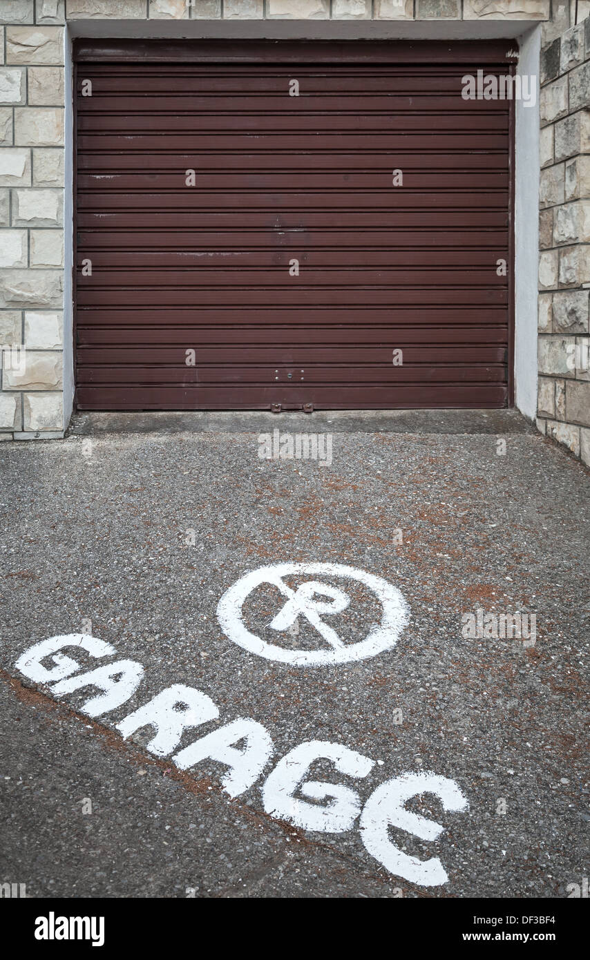 Attenzione text mark su asfalto di fronte chiuso la porta del garage Foto Stock