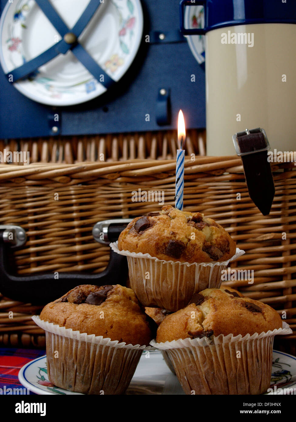 Muffin con candela blu nella parte anteriore del cesto per pic-nic, REGNO UNITO Foto Stock