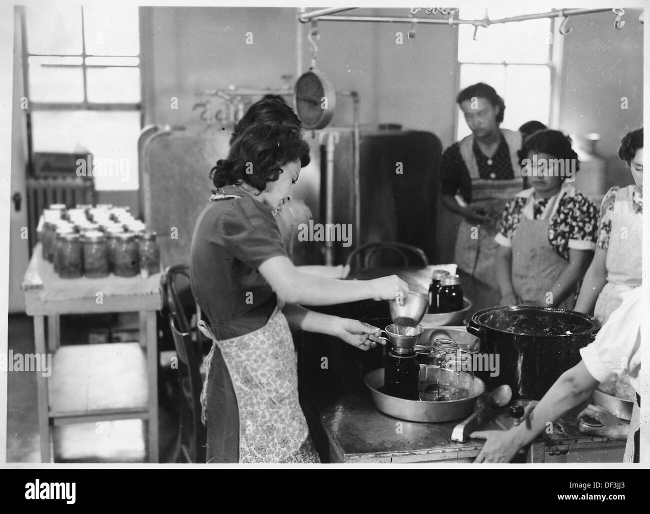 L'inscatolamento dei prodotti per la conservazione comporta la lavorazione di frutta e verdura per prolungarne la durata di conservazione, spesso attraverso la sigillatura in vasetti o contenitori. Foto Stock