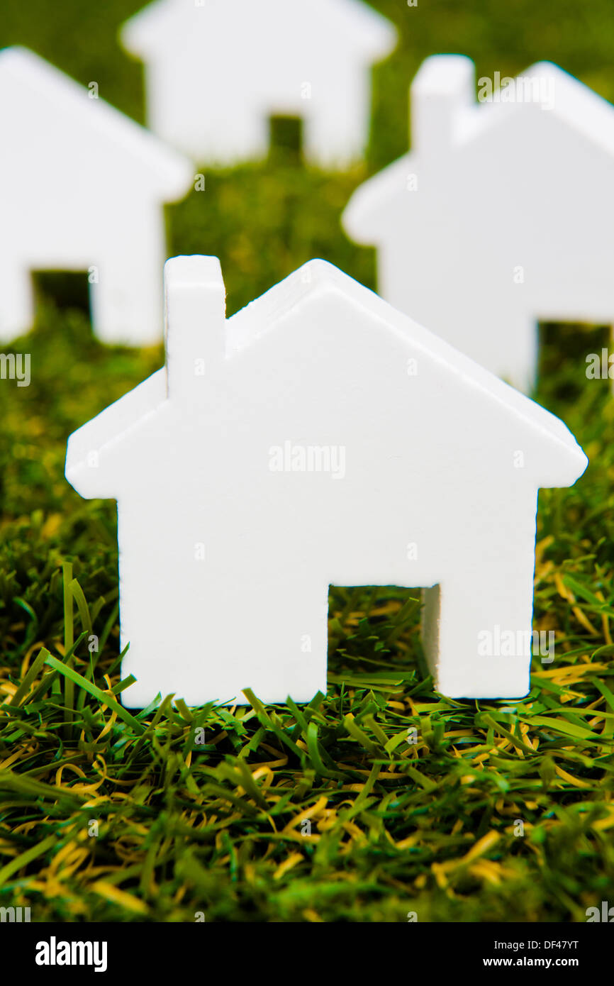 Serie di modello bianco casa disposto sull'erba Foto Stock