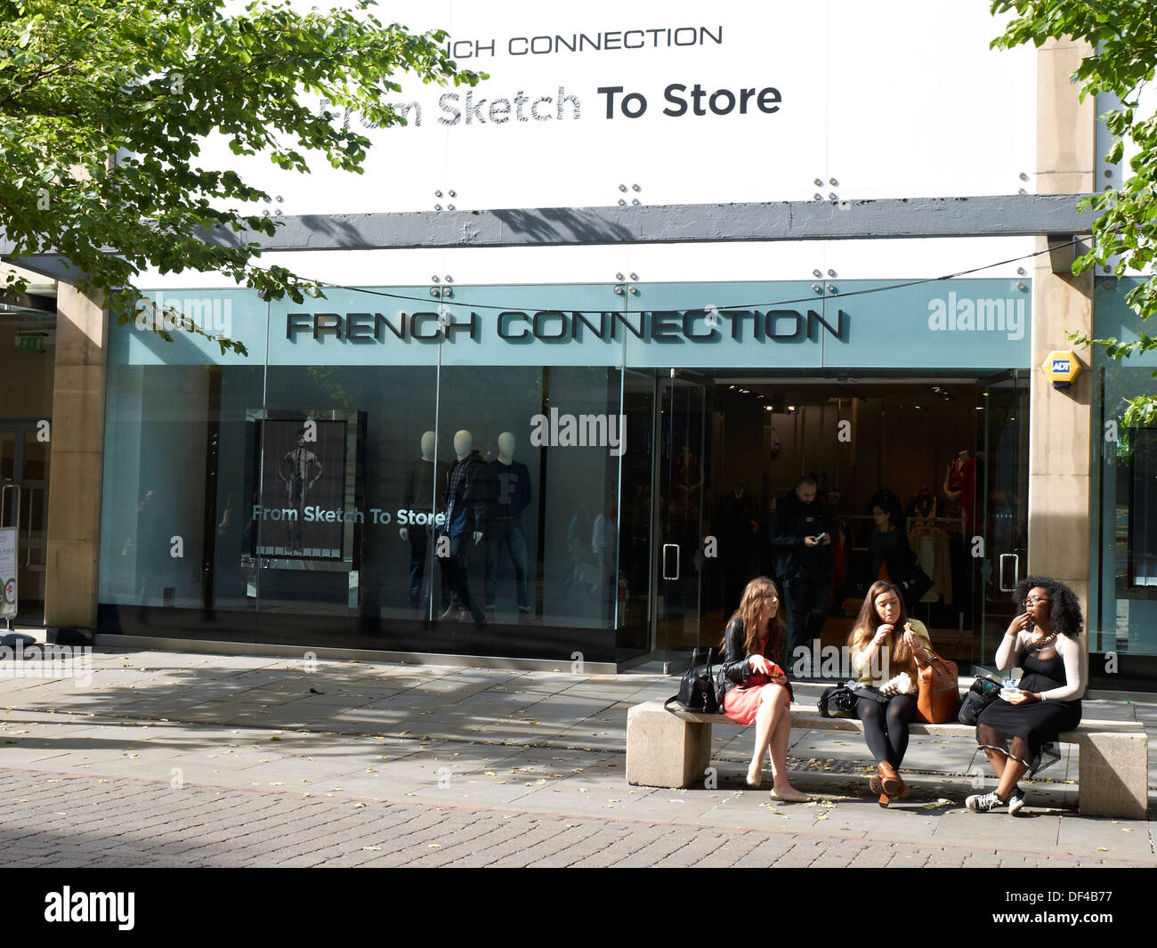 Gli impiegati hanno il pranzo di fronte French Connection store a Manchester REGNO UNITO Foto Stock