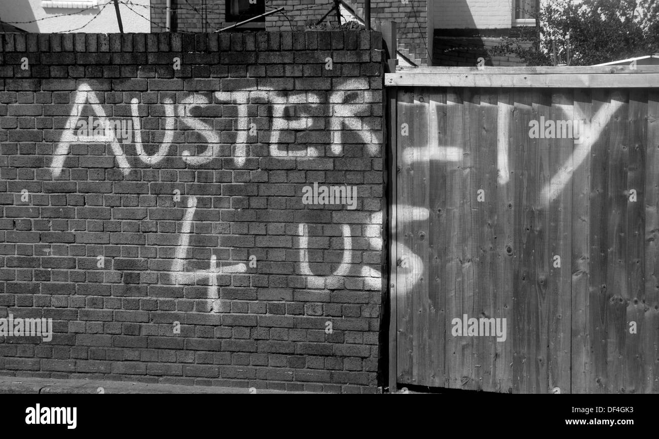 Graffiti che condanna la politica economica "austerità 4 Us' vernice bianca su un muro di mattoni Cardiff Wales UK Foto Stock