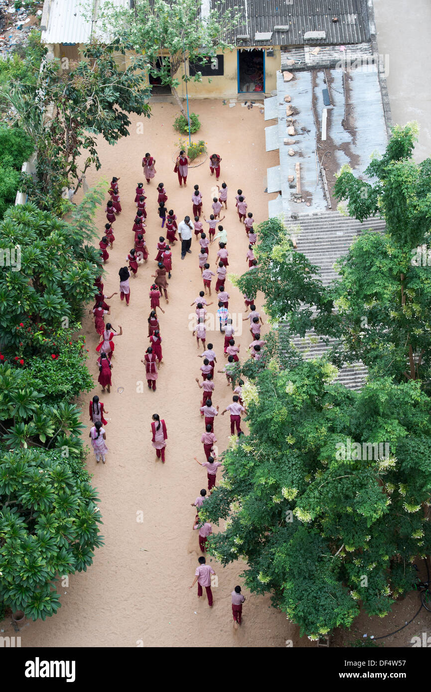 Guardando verso il basso su un Indiano inglese scuola media e della scuola i bambini a fare gli esercizi. Puttaparthi, Andhra Pradesh, India Foto Stock