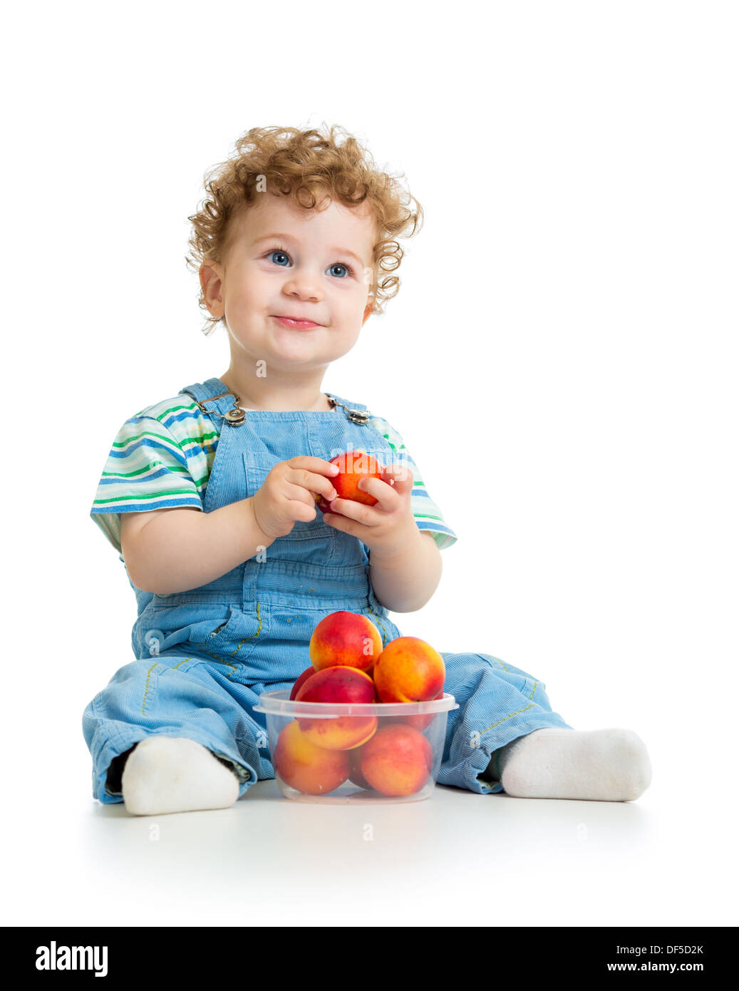 Baby boy mangiare frutta isolato su sfondo bianco Foto Stock